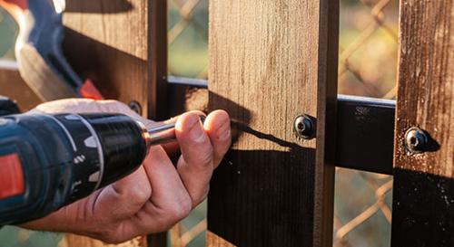 Closeup screwing in new fence paling